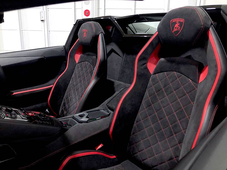 ヘッドレスト部にはランボルギーニのシールドが。 シートの間のリヤウインドウを開ければ、走行中のV12エンジンのエキゾーストノートをよりリアルに楽しめます。(16/26枚) ランボルギーニ アヴェンタドール S ロードスター ブラック MY2018